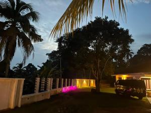 a truck parked in front of a house with pink lights at The Highland Manor in Weligama