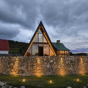 a stone wall with a house on top of it at Falcon View Zabljak in Žabljak