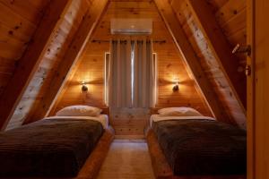 two beds in a room in a log cabin at Falcon View Zabljak in Žabljak