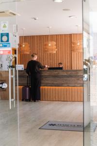 a man standing at a counter in an office at Mareta Beach - Boutique Bed & Breakfast in Sagres +39 photos