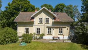 a yellow house with a bench in a yard at Kanalvillan Dalsland in Dals Långed