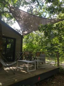 a patio with two chairs and a table on a deck at Lodge avec terrasse in Charmeil