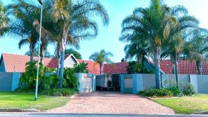 a driveway leading to a house with palm trees at Myrtle Leaf Apartments in Springs