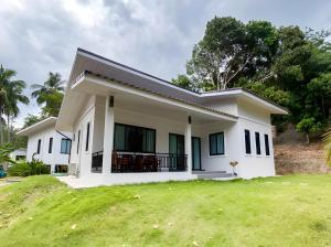 a small white house with a grass yard at Soul House - Stay Beautifully in Ko Kong Nui