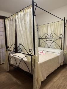 a bedroom with a black canopy bed with curtains at Le Coccole Del Trasimeno in Tuoro sul Trasimeno +69 photos