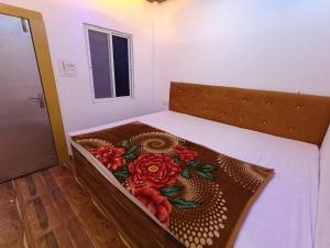a bed with a wooden frame with flowers on it at Hotel shree jagannath palace in Ujjain