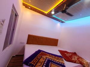 a small bedroom with a bed with a ceiling at Hotel shree jagannath palace in Ujjain