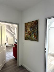 a painting on a wall in a room with a red couch at Brauhaus Suite 20 in Sebnitz