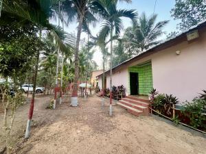 a building with palm trees in front of it at Sai beach Resort in Diveagar