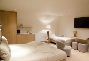 a hotel room with two beds and a flat screen tv at Huis Leon in Houthulst