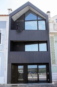a tall black building with glass windows at Fisherman's View in Aveiro