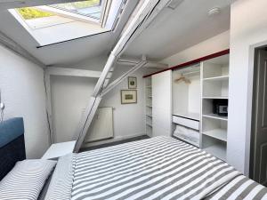 an attic bedroom with a bed and a skylight at Brauhaus Suite 20 in Sebnitz +15 photos