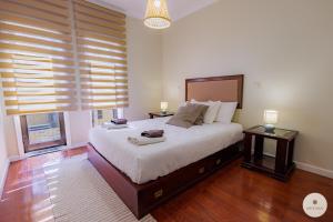 a bedroom with a large bed and a large window at Apartamento Ruy Belo - Foz in Vila do Conde