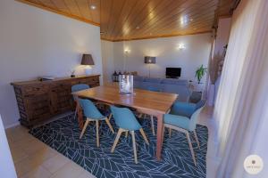 a dining room with a wooden table and blue chairs at Apartamento Ruy Belo - Foz in Vila do Conde