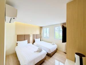 a hotel room with two beds and a television at Le Hong Hotel Pratunam in Bangkok
