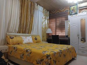 a bedroom with a yellow bed and a desk at A & J Services in Tesa