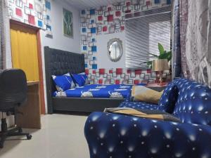 a living room with a blue couch and a bed at A & J Services in Tesa