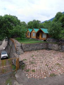 a group of cottages with a car parked in front at Wildwood Cabins Manali in Kulu