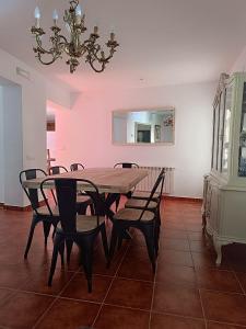 a dining room with a table and chairs and a chandelier at Casa Rural Gafas in El Toboso