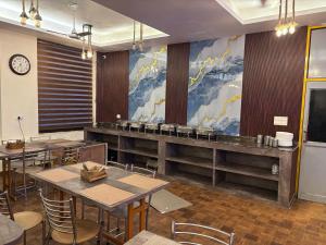 a dining room with tables and chairs and a mural at Corbett Treat Resort in Rāmnagar
