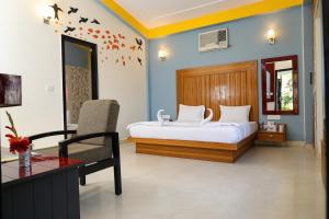 a bedroom with a bed and a chair and a desk at Corbett Treat Resort in Rāmnagar