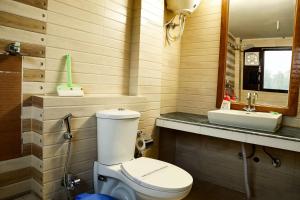 a bathroom with a toilet and a sink at Corbett Treat Resort in Rāmnagar
