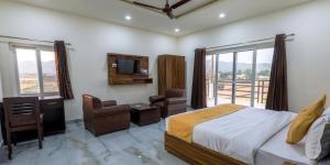 a bedroom with a bed and a desk and a television at Corbett Treat Resort in Rāmnagar +8 photos