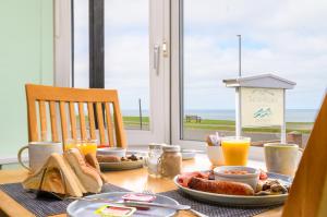 a table with breakfast foods and orange juice on it at The Wheeldale in Whitby