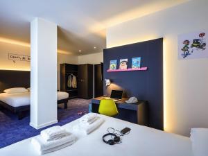 a hotel room with a bed and a desk with a laptop at ibis Styles Liege Guillemins in Liège +98 photos