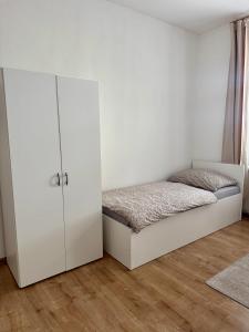 a bedroom with a bed and a white cabinet at StayU Apartment in Ústí nad Labem