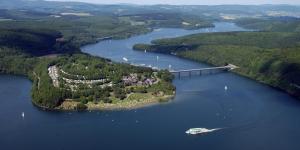 eine Luftansicht auf einen Fluss mit einer Brücke und einem Boot in der Unterkunft Haus Bahlo - Ferienwohnungen in Attendorn