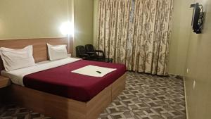 a bedroom with a bed with a laptop on it at Hotel sunrise in Kodaikānāl