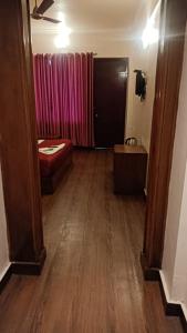 a hallway of a room with a bed and a door at Hotel sunrise in Kodaikānāl