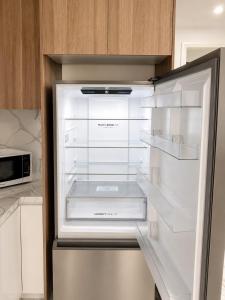 an empty refrigerator with its door open in a kitchen at Modern Private Granny Flat Free Parking in Riverstone