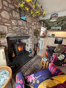 a living room with a stone wall with a fireplace at Loch Ness village cottage for 2 with free parking & pets welcome in Drumnadrochit