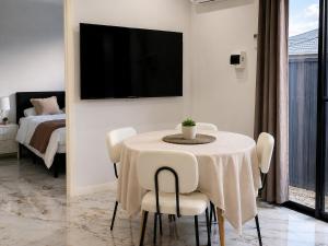a dining room with a table with chairs and a tv at Modern Private Granny Flat Free Parking in Riverstone