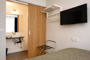 a room with a bed and a television on a wall at ASKA Heiðmörk in Reykjavík