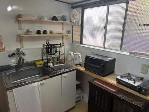 a small kitchen with a sink and a microwave at HANA88のa,b in Otsu
