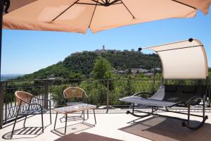 a patio with two chairs and an umbrella at La Terrazza del benessere in Ferrazzano