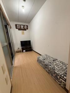 a room with a bed and a flat screen tv at HANA88のa,b in Otsu
