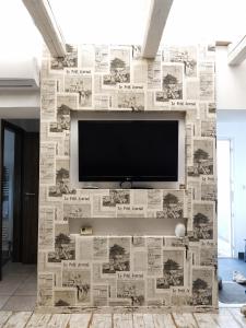 a tv on a wall covered in newspapers at Ady Házikó in Pécs