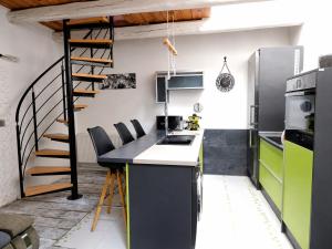 a kitchen with a counter and a spiral staircase at Ady Házikó in Pécs