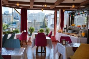 a restaurant with tables and chairs and a view of a city at Old Town Hotel in Baku