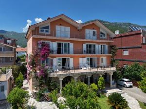 an apartment building with a balcony in a city at Apartment Orange Blossom First Line & Pool 1 in Bijela