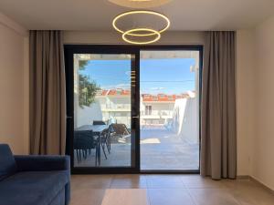 a living room with a glass door leading to a patio at Villas Kaiafa “Ismini” in Polychrono +98 photos
