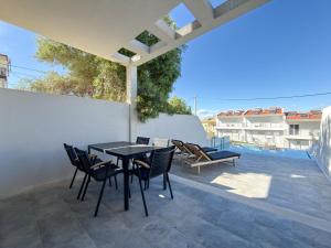 a patio with a table and chairs on a roof at Villas Kaiafa “Ismini” in Polychrono