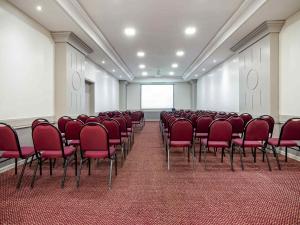 a conference room with red chairs and a screen at Intercity Curitiba 7 de Setembro in Curitiba