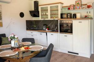 a kitchen with white cabinets and a table and chairs at Casa Carlo in Sinj +16 photos