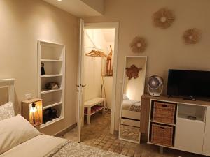 a bedroom with a bed and a television on a cabinet at MancioBiba Home in Trevi