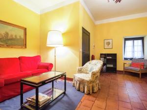 een woonkamer met een rode bank en een stoel bij Belvilla by OYO Nobile in Tagliolo Monferrato